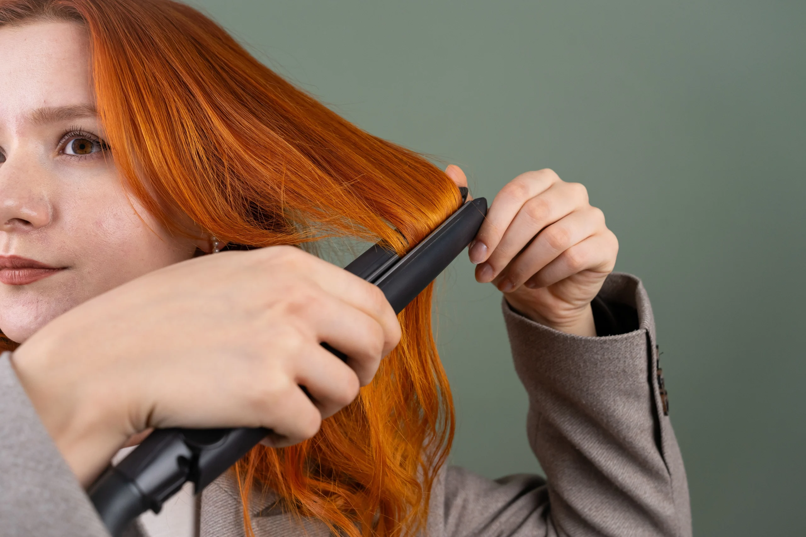 Applying heat protectant spray to hair before straightening, Doncaster